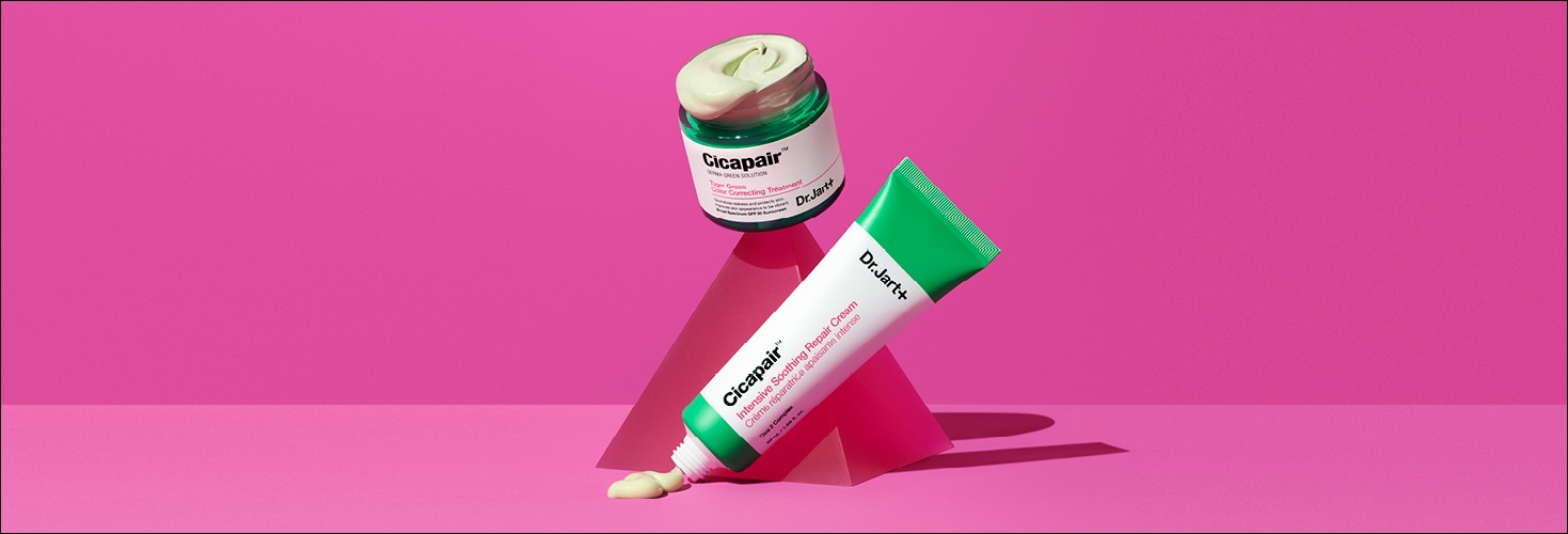 An open jar of Dr.Jart+'s color correcting treatment and Cicapair Cream are balanced on pink abstract elements.