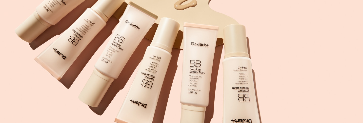 Six bottles of Dr.Jart+'s Premium BB Tinted Moisturizer with SPF 40 lean against peach backdrop