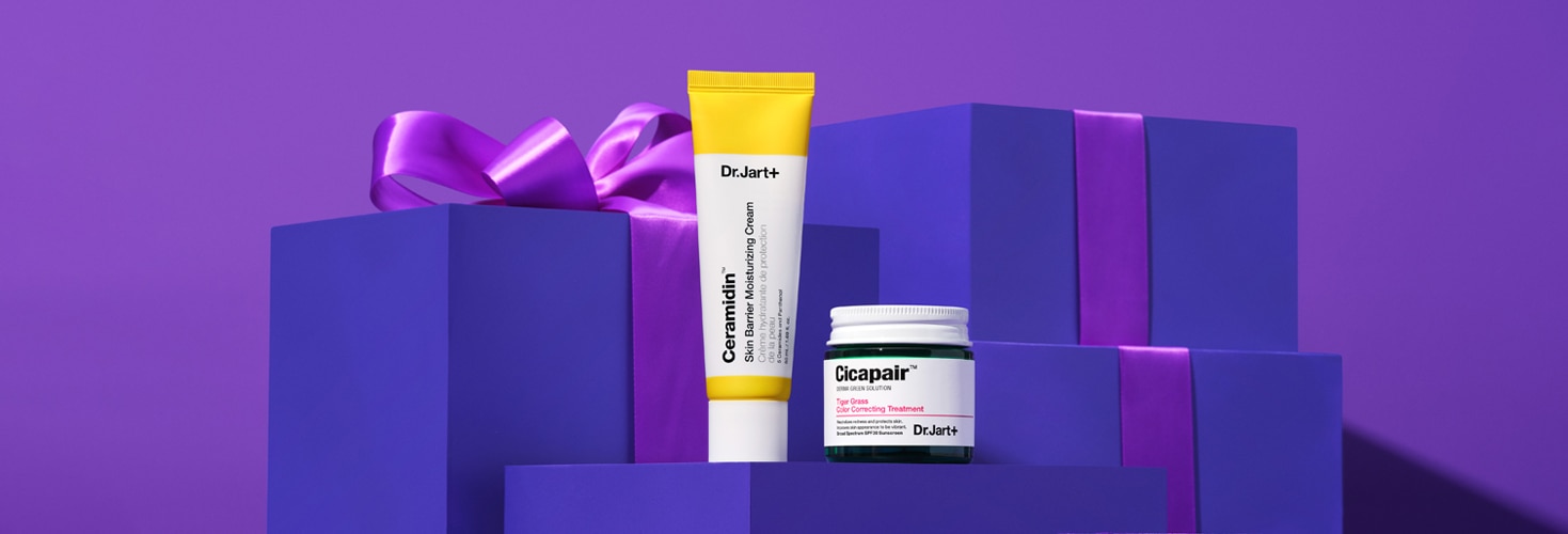 Ceramidin moisturizer cream and Cicapair Color Corrector stand in front of purple giftboxes with elegant purple ribbons.